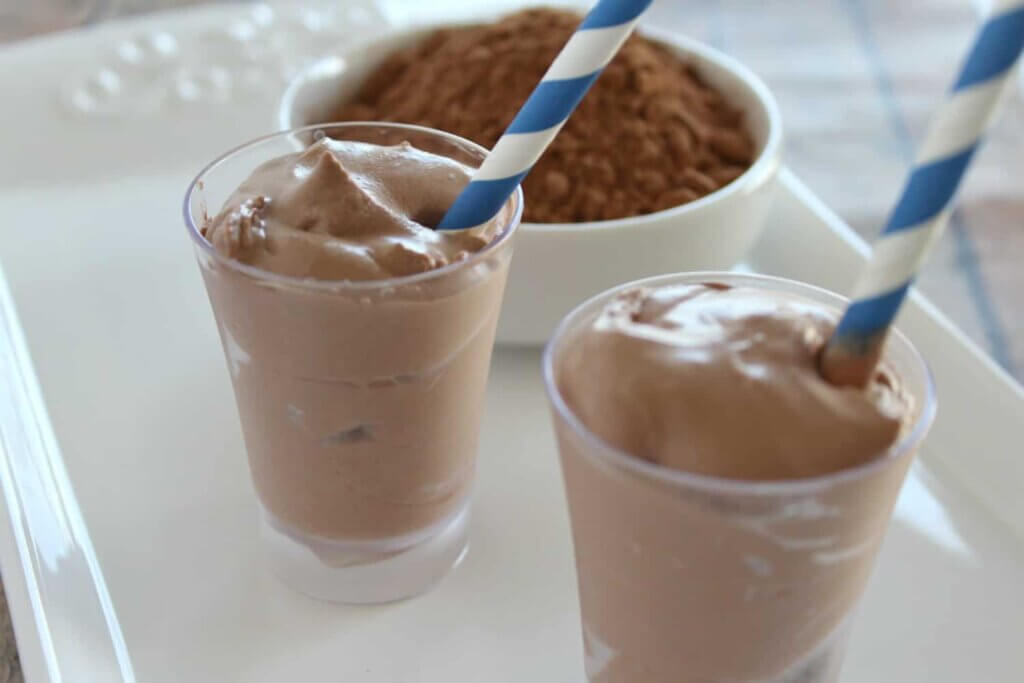 two clear cups with a chocolate frosty dessert