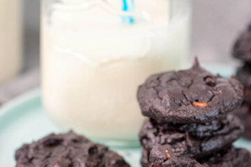 keto chocolate cookies on tray with a glass of milk