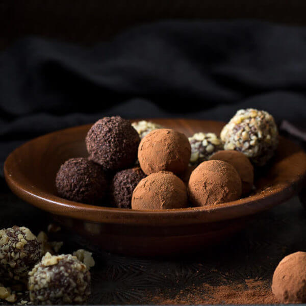 an assortment of homemade chocolate truffles in wooden bowl