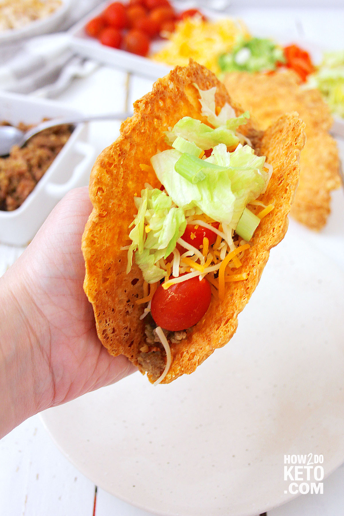 hand holding a taco made with cheese shell