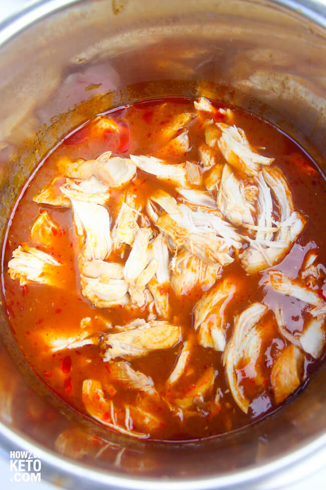 shredded chicken in Instant Pot with enchilada sauce