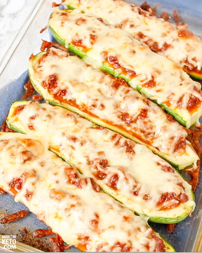 casserole dish filled with keto stuffed zucchini, topped with pizza sauce and cheese