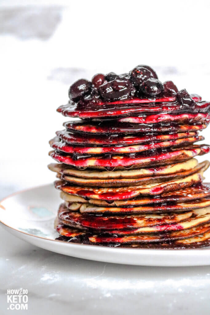 tall stack of keto blueberry pancakes with blueberry syrup