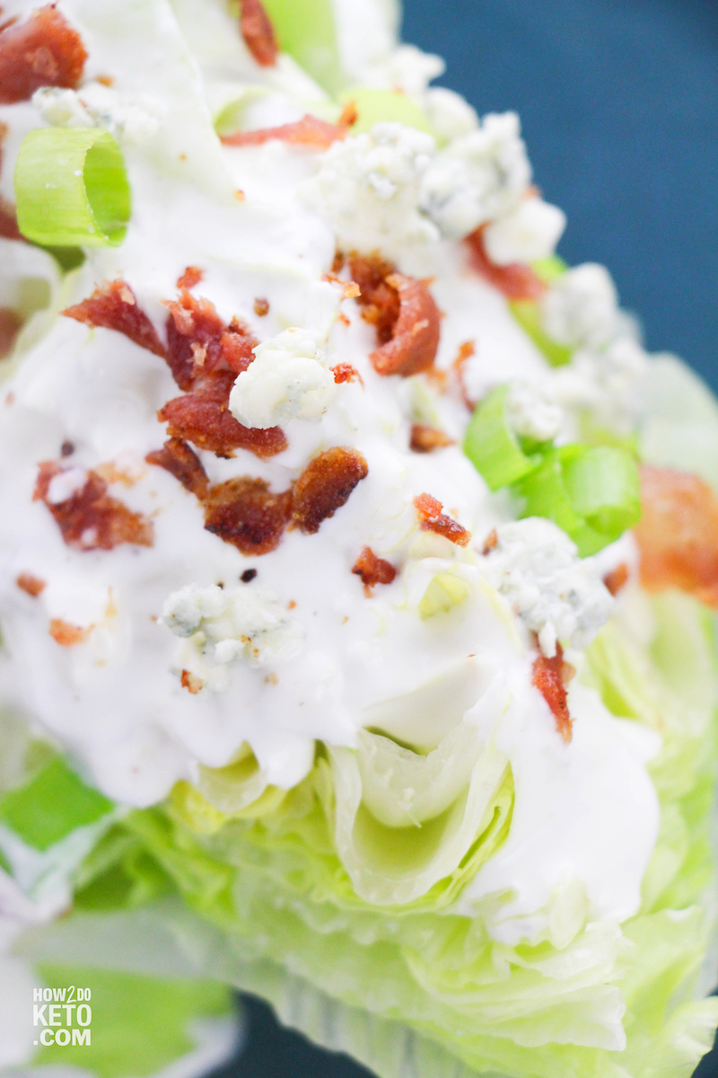 close up of blue cheese dressing on wedge of iceberg lettuce