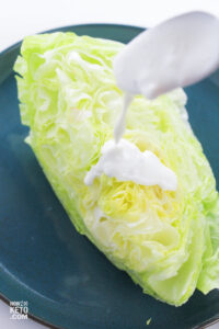 pouring blue cheese dressing on iceberg wedge