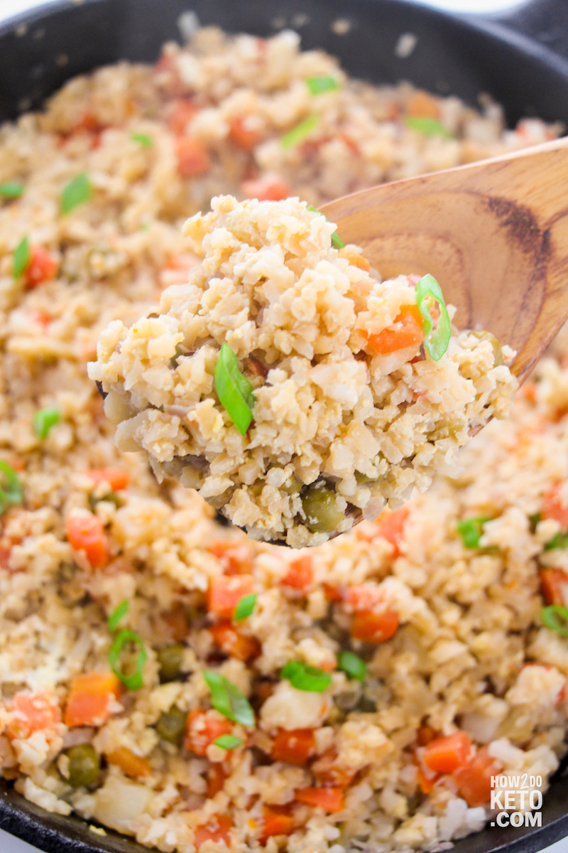 stirring keto fried rice with wooden spoon