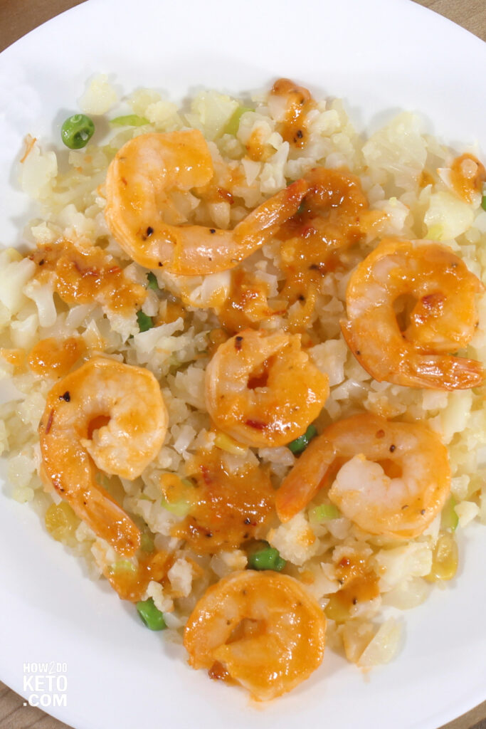 top down photo of shrimp over cauliflower rice, in a chili based sauce