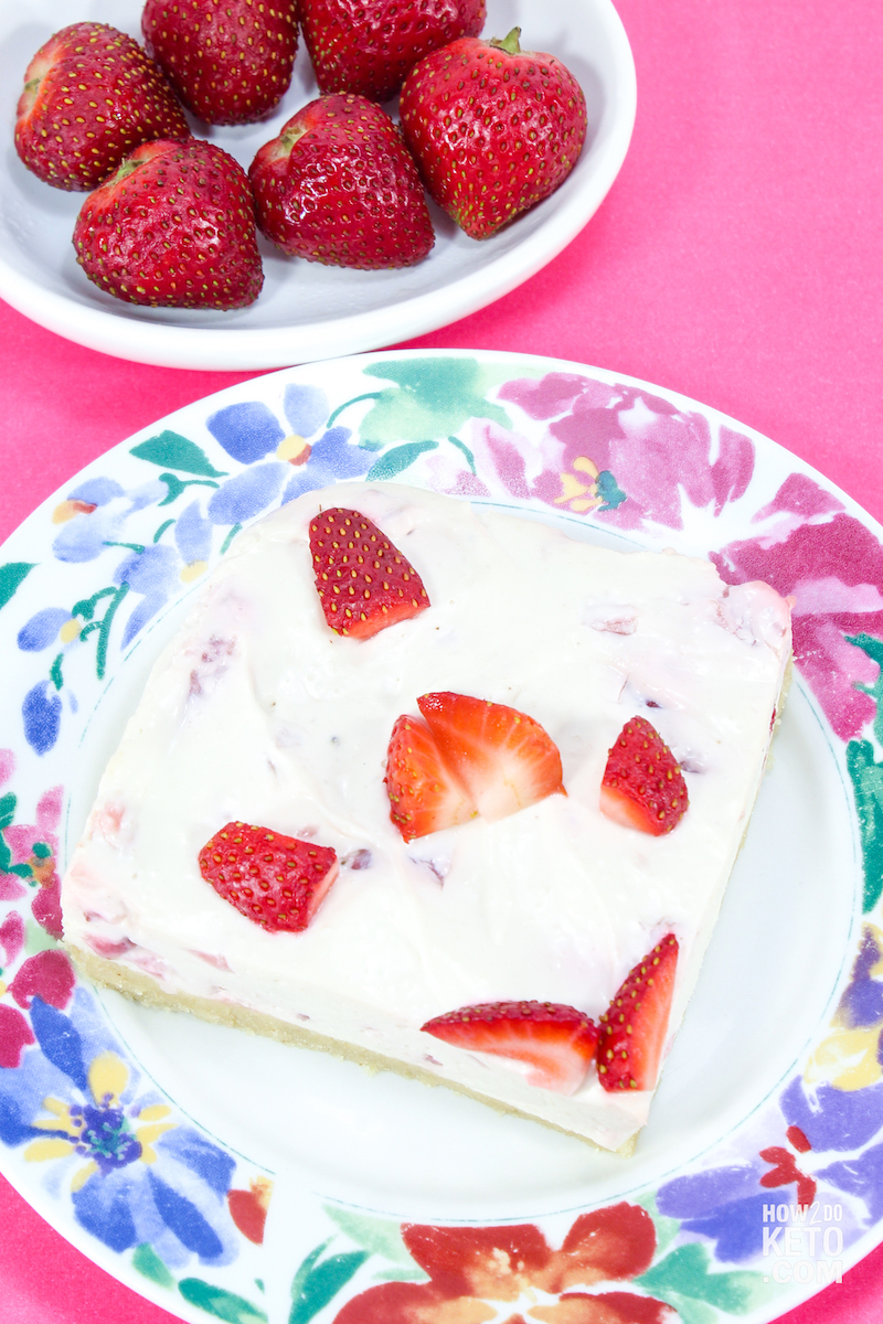 strawberry & cream cheesecake slice with a bowl of fresh strawberries