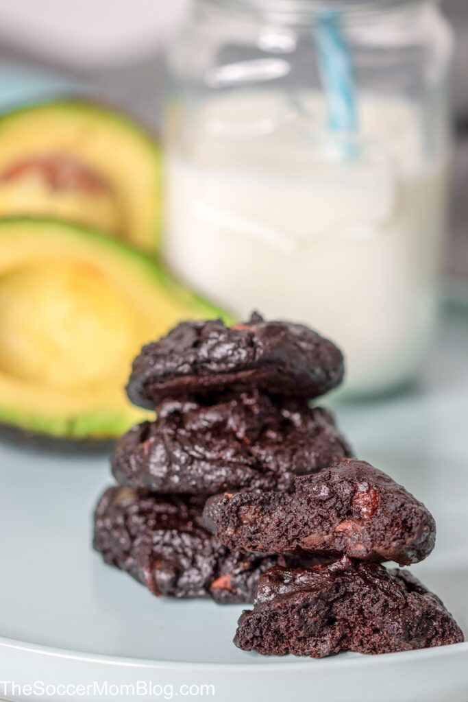 stack of chocolate cookies with avocados and glass of milk