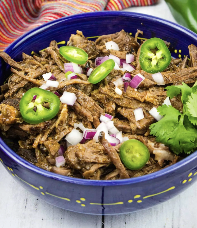 bowl of barbacoa topped with jalapenos and onions