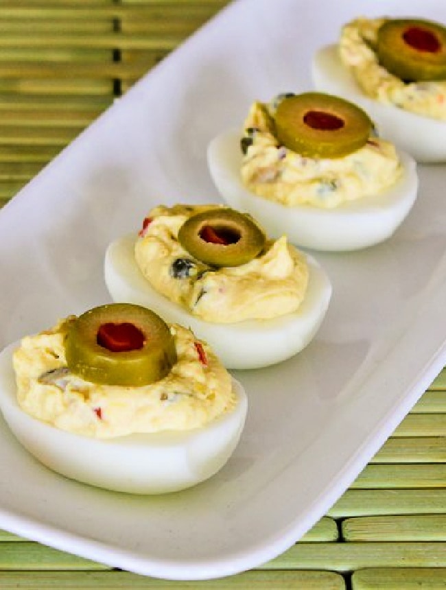 deviled eggs topped with sliced green olives