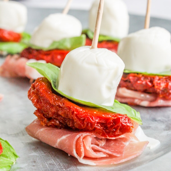 skewers of meat, sun dried tomato, basil, and mozzarella