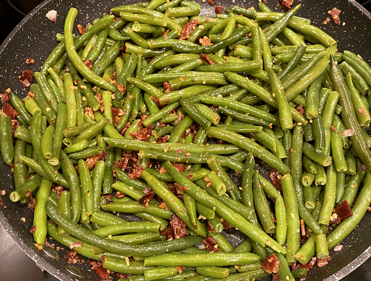 pan of green beans topped with crispy minced garlic
