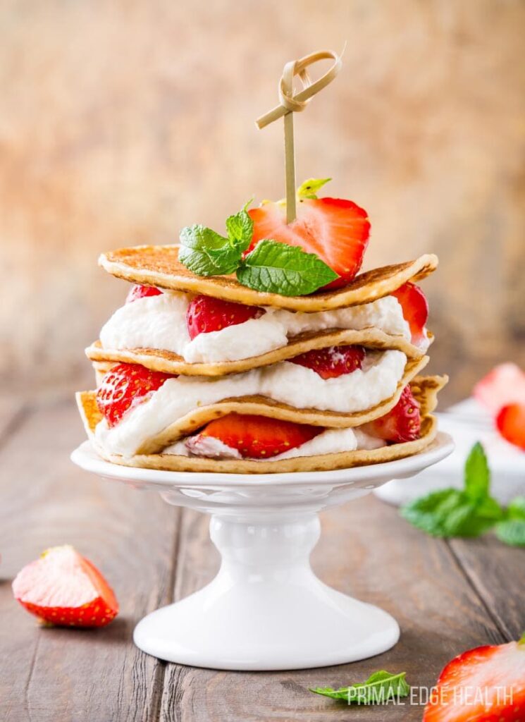 stack of thin keto pancakes filled with strawberries and cream
