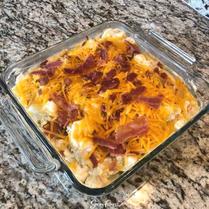 casserole dish of cauliflower mac and cheese topped with bacon