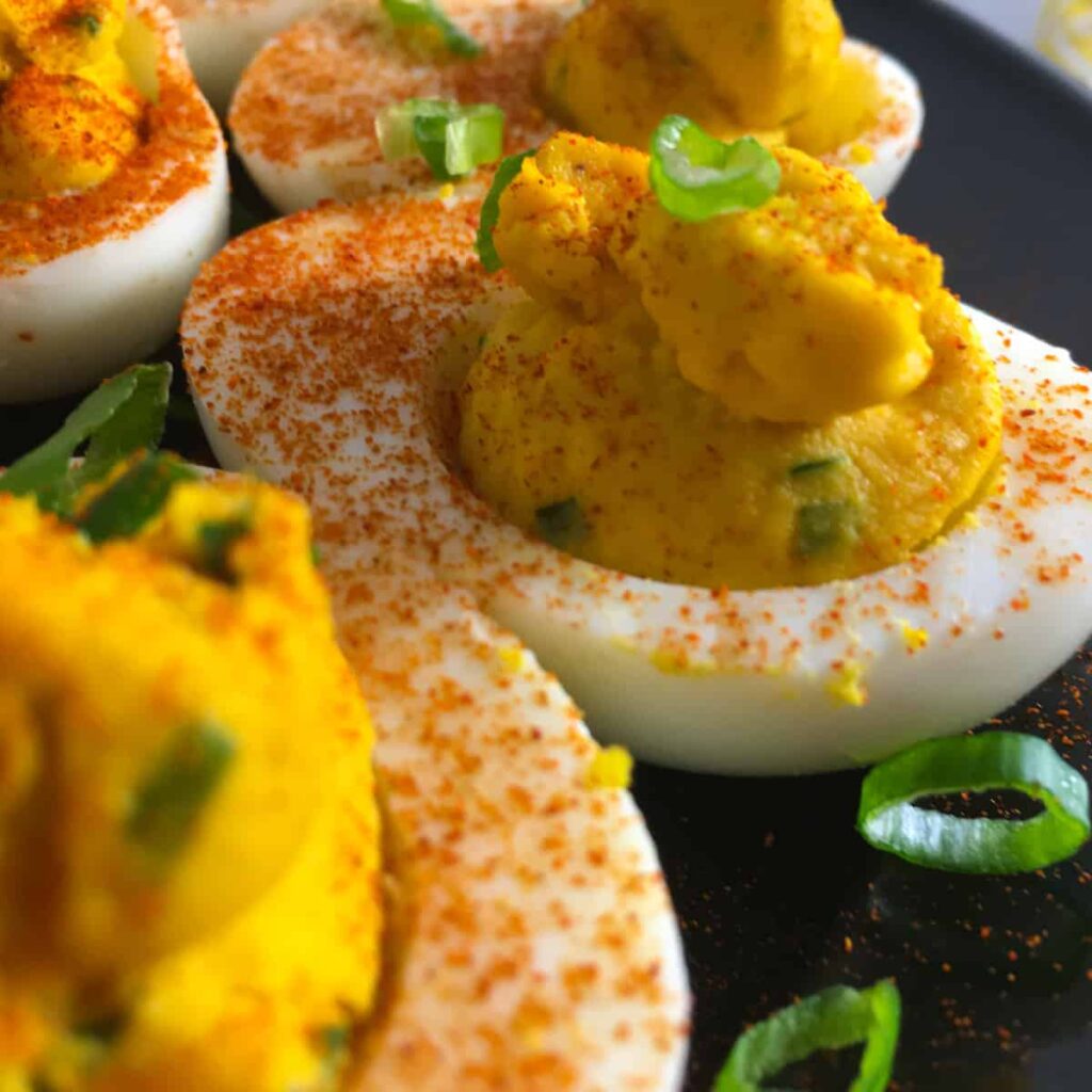 deviled eggs topped with chipotle pepper and green onions