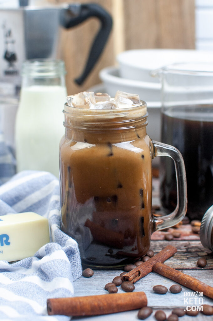 Keto Iced Coffee, surrounded by ingredients such as butter and cinnamon