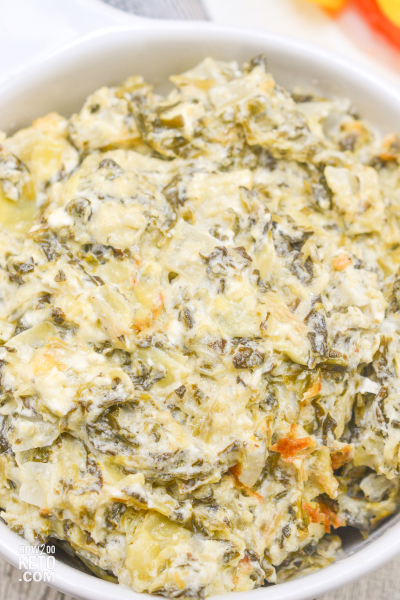 Close up view of Keto Crockpot Spinach Artichoke Dip in white bowl
