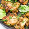 chicken thighs with lime and cilantro, cooking in cast iron skillet