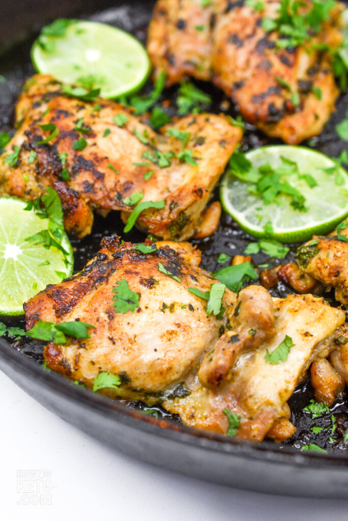 chicken thighs with lime and cilantro, cooking in cast iron skillet