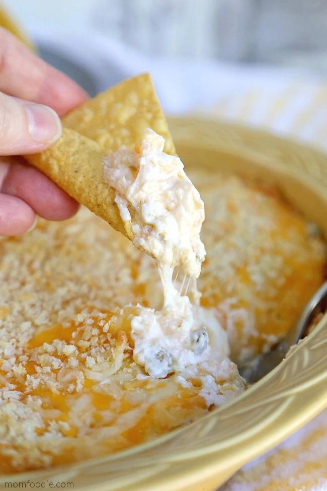 tortilla chip dipping into bowl of jalapeno popper dip